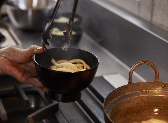 画像: ３ 別鍋にお湯を沸かし、うどんを入れて軽く温め、うどんを器に取り分ける。