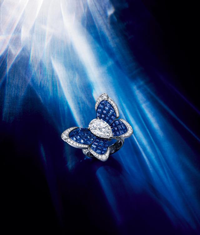 画像: メゾン独自の技法、＂トラディショナル ミステリーセット＂で石を留める金具を見せずに仕立てられたサファイアの蝶は、今にも指先から優雅に飛び立ちそう。中央のペアシェイプのダイヤモンドも比類なき輝きをたたえて見事。「カリマ パピヨン リング」〈18KWG、18KRG、サファイア、ペアシェイプダイヤモンド1 石（DFLタイプ2A、3.12ct）、ダイヤモンド〉（参考商品）／ヴァン クリーフ＆アーペル ヴァン クリーフ＆アーペル ル デスク TEL.0120-10-1906