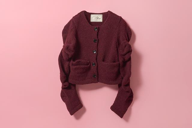 画像: 引き返し編みという技法でうねりを出しながら、いびつに編んでいく。パフスリーブよりも甘すぎない、袖の表情も絶妙。「西洋では身体のラインをどう美しく見せるかということを重視するが、日本の偉大なデザイナーたちは身体の線を見せず、隠しながらどう情緒を見せていくかを表現し、世界を相手に道を拓いてきた。そこに大きなリスペクトを感じています。」実際に着てみると、身体も腕回りもふわりと包み込んできれいに見せてくれるのもうれしいが、軽くて温かくて、そして着ていてなんだか楽しい。カーディガン¥88,000/ピリングス