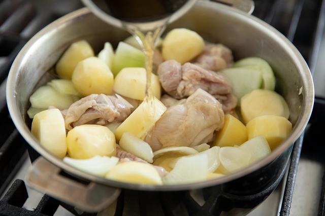 画像: 鶏肉の表面が白くなったら、じゃがいもを加える。軽く混ぜ合わせ、水と白ワインを同量ずつ混ぜたものを注ぎ、蓋をして火を弱めて15分ほど煮込む。