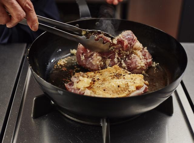 画像: 3皮に焦げ目がついたらひっくり返し、鶏肉の上に残りのにんにくをのせる。