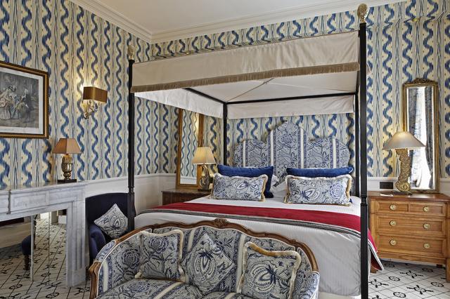 画像: ベッドに天蓋が付いたデラックスルーム。照明器具に客室の個性が現れている