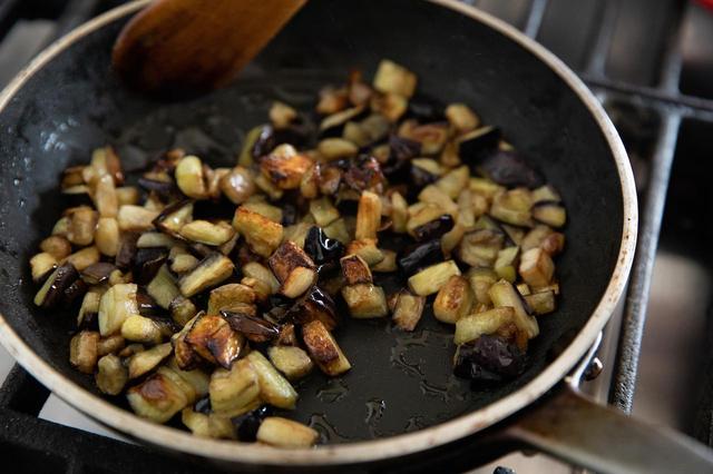 画像: フライパンにオリーブオイル大さじ2を入れて中火にかけ、なすを炒める。塩を振り、全体がしんなりするまで炒める。焼き色がついたら、にんにくとクミンシードを加え、さらに香ばしく炒め合わせる。