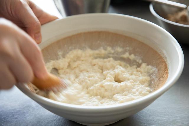 画像: すり鉢に豆腐を入れて泡立て器でほぐす。だしを少しずつ入れ、すりこぎで混ぜる。