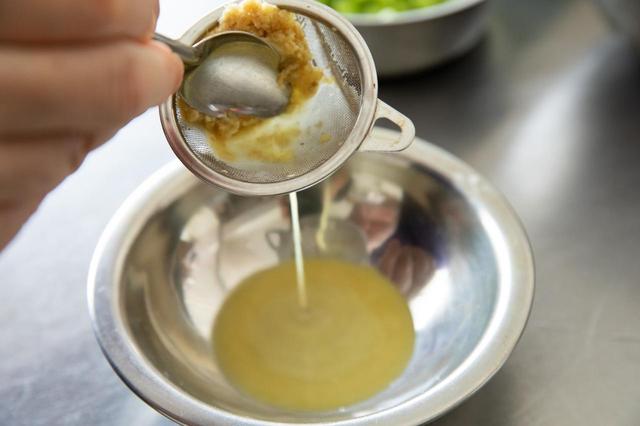 画像: 生姜のすりおろしを茶漉しに入れ、スプーンでボウルに濾し入れる。オリーブオイルを加えて、よく混ぜ、「生姜オイル」を作る。