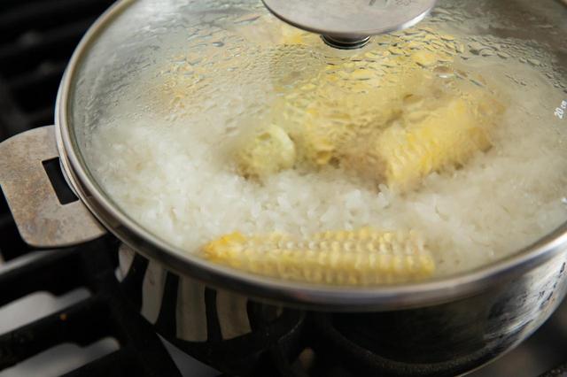 画像: 米を研いでざるにあげて20分以上おく。とうもろこしは2等分し、まな板に立ててナイフで実を削ぐ。鍋に米を入れ、とうもろこしの芯をのせ、塩を振り、米と同量の1割増しにした水を注ぐ。蓋をして中火にかけ、煮立ってきたら弱火にし、12分ほど炊いて火を止める。