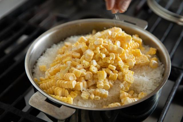 画像: とうもろこしの実をご飯の上にのせて軽く塩を振り、全体をざっと混ぜて蓋をし、7〜9分蒸らす（とうもろこしご飯は炊飯器で炊いてもいい）。炊飯器で炊く場合も同様にする。器に盛り、スープに添える。