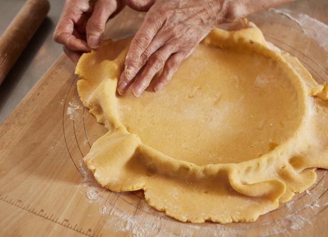 画像: 5 生地を型の内側に沿わせて、側面と底を貼り付けるようにする。隅は指先を使ってしっかり押し込む。