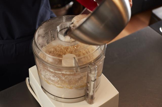 画像: １ フードプロセッサーに強力粉と薄力粉を入れ、数回攪拌する（これでふるったことになる）。卵と牛乳各半量を加えては軽く回す。イーストと砂糖を入れておいたぬるま湯を加えて、軽く回す。残りの卵と牛乳を加えてさらに回す。