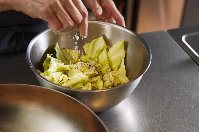 画像: ３ キャベツをボウルに入れ、オリーブオイルを回しかけ、黒胡椒を挽きかける。塩を振り、よく混ぜる。