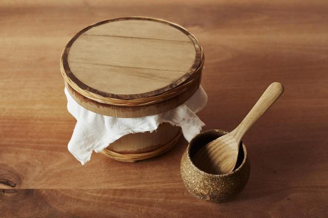 画像: 4 移し終えたら、さらしのふきんをはさんで蓋をする。しゃもじと水を入れた器を添えておく。杉の香りがごはんに合うと、杉の木製のおひつを使用。