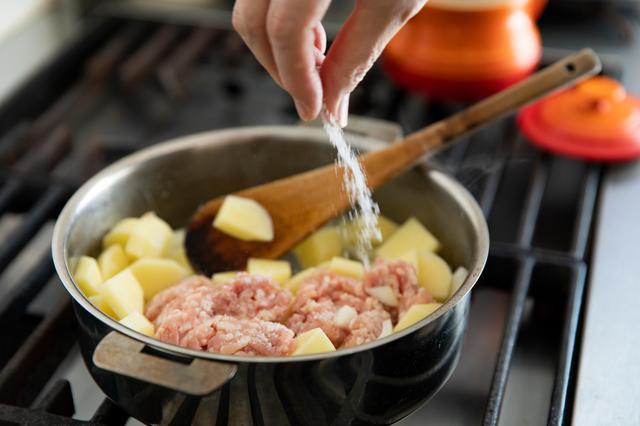 画像: 鶏挽き肉のスープを作る。鍋にバターとにんにくを入れて弱火にかけて炒める。にんにくの香りが立ってきたらじゃがいもと玉ねぎ、鶏挽き肉を入れ、木べらでほぐしながら炒め合わせ、途中で軽く塩を振る。水約200ml（材料外）を加えて蓋をし、野菜がやわらかくなるまで弱めの火加減で15分ほど蒸し煮する。