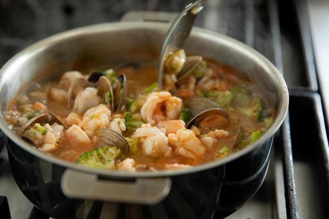 画像: えびを加え、火が通ったら赤唐辛子粉を振ってざっと混ぜて火を止め、器に盛る。くし形に切ったレモンとオリーブオイル（分量外）を添える。