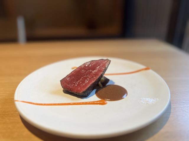 画像: コースのメインは和漢草を食べて育った宮城県産漢方牛の薪火焼き¥1,400プラス。どぶろくでコクを加えた赤ワインソースやクローブが香るパプリカソースが添えられているが、自作の薬膳七味ともよく合う