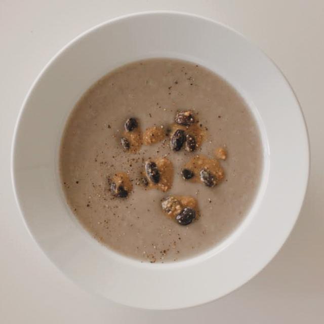 画像: 『ごぼうと黒豆のポタージュ』。黒い食材から生まれたスープはおだやかな色。「この味わいは自分でも気に入っています」。同じ食材で染めた布は、淡く透きとおった静謐な色。布の色とスープの色を、会場で見比べるのも楽しい。 ©KYOTARO HAYASHI