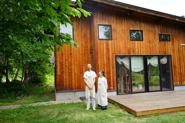 画像: お店の前の中西宙生さんと貴子さん。「toi」の設計は、伊勢神宮の式年遷宮を手掛けた宮大工の菅原雅重さんが帯広にUターンし、設立した建築設計事務所「おかげさま」に依頼