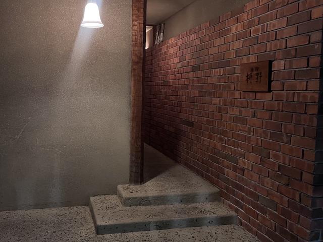 画像: 店内まで続くレンガ造りの壁に掛けられた看板が目印