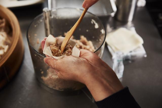 画像: 4 皮であんを包む。小さなヘラもしくはスパチュラを使い、皮に肉あんをのせる。肉あんの真ん中にヘラを刺す。