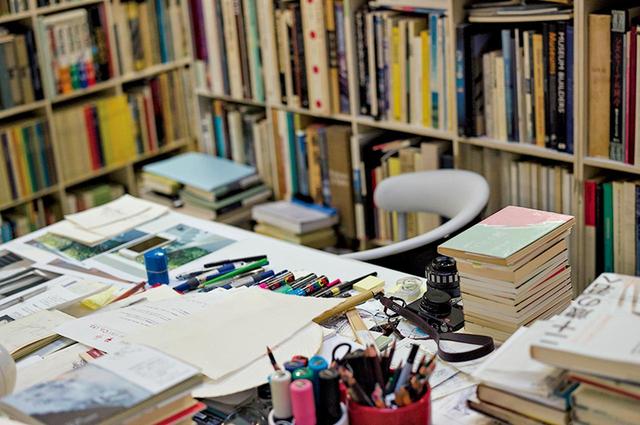 画像: 事務所のほぼ中央、吹き抜けの下にある安藤のスペース。スケッチや筆記用具のほか、いつも本が山積みになっている PHOTOGRAPH BY SHINGO WAKAGI