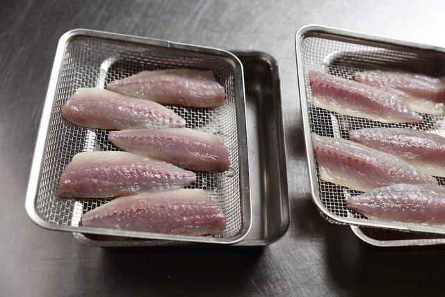 画像: １ 鯵を酢締めにする。 鯵は三枚におろして骨を抜く。角ざるに鯵を並べ、両面に軽く塩を振り、バットに斜めにして30分ほどおく（暑い時期なら冷蔵庫に入れる）。