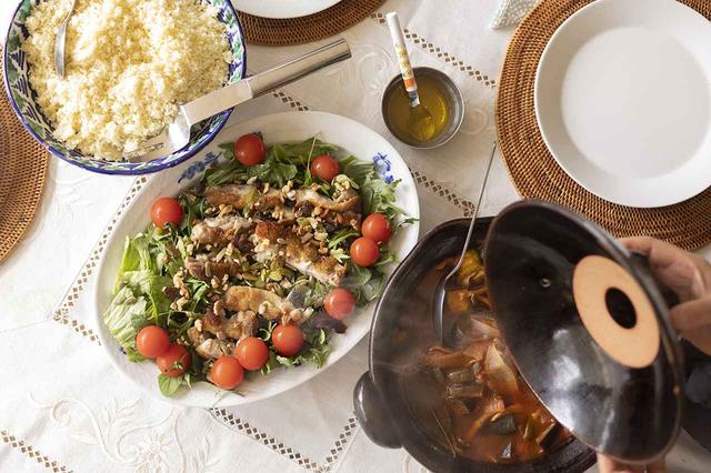 画像: 藍の装飾が美しいロイヤルコペンハーゲンのオーバル皿にはグリルチキンのサラダ、福森道歩さんの伊賀焼の土鍋には熱々のラタトゥイユを。工藝社でお母様が求めたスペイン製のボウルにはクスクスを。器や料理が真っ白なリネンのクロスを表情豊かに彩って