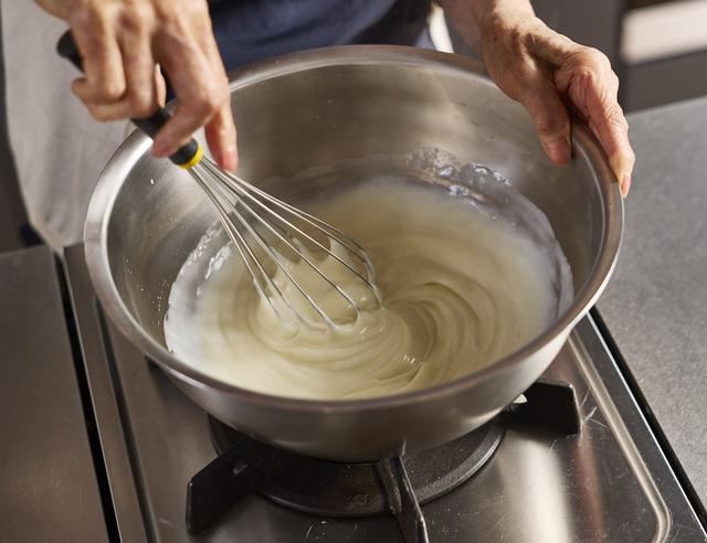 画像: 3ぬれぶきんをそばに用意し、2を中火にかけ、泡立て器で焦げつかないようにしっかり混ぜる。