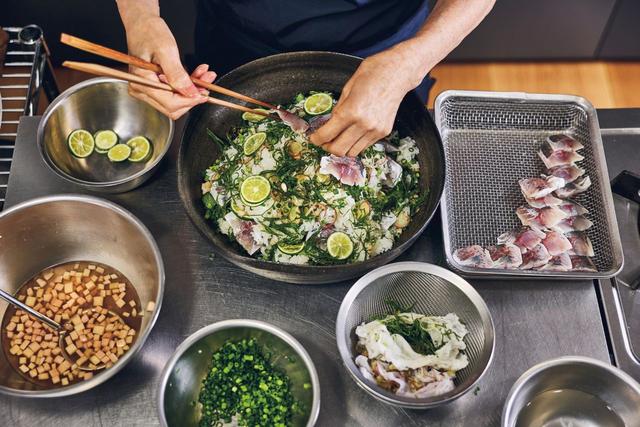 画像: 「鰺の混ぜずし」は、有元が料理家として初めて作った料理だ。三枚におろした鰺は酢締めに。米3合を炊き、「千鳥酢」80㎖、メープルシロップ大さじ1と1/2、塩小さじ2/3を混ぜ合わせて酢飯を作る。小口切りにして塩もみしたきゅうりを酢飯に加えて混ぜ込む。薬味はしょうが、みょうが、大葉、細ねぎ、すだちを用意。大きな器に酢飯、直前に皮を剝いでそぎ切りにした鰺、薬味類を順にのせる。これを2、3回繰り返す。長崎出身の母は、故郷では目の前の海で取れた鯛を使っていたためか、混ぜずしには鯛がお決まりだったそう。有元は季節の具材をのせ、記憶の味をたどって作り上げた。
