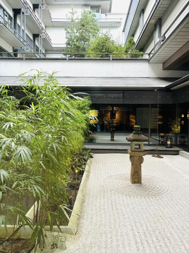 画像: 館内のアートツアーもあり、かつてここにあった老舗ホテルフジタ京都から受け継いだ400年ほど前の灯篭には、マリア像が彫られている。10日おきに整えているという石庭も美しい