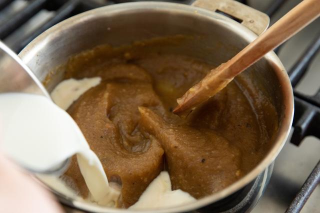 画像: 焼きいものピュレを鍋に入れ、残りの水を加えて弱火にかける。木べらで混 ぜながら溶きのばし(硬いようなら少し水を加えて調整する)、てん菜糖を 加えて混ぜ合わせる。よく馴染んだら牛乳を静かに加え、温める程度に煮て火を止める。