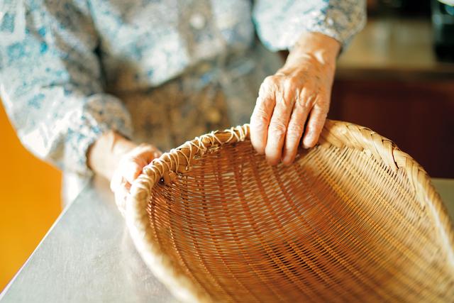 画像: 大きな竹ざるの縁の部分を、ひもを使って修理し、使いつづけている