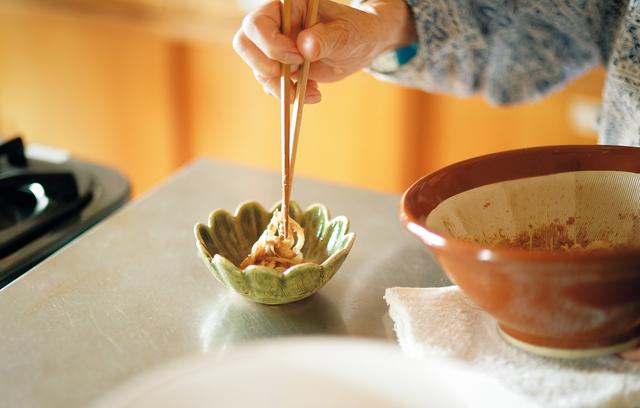 画像: 玉ねぎを、ごまとしょうゆであえ、盛りつける。玉ねぎは自然農法のもの、しょうゆは伝統製法でつくられたものを使う