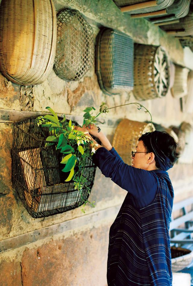 画像: 花をあしらった場所は、かごやざるが並ぶ廊下。これらのかご類は草取りや畑仕事に使っているのだそう