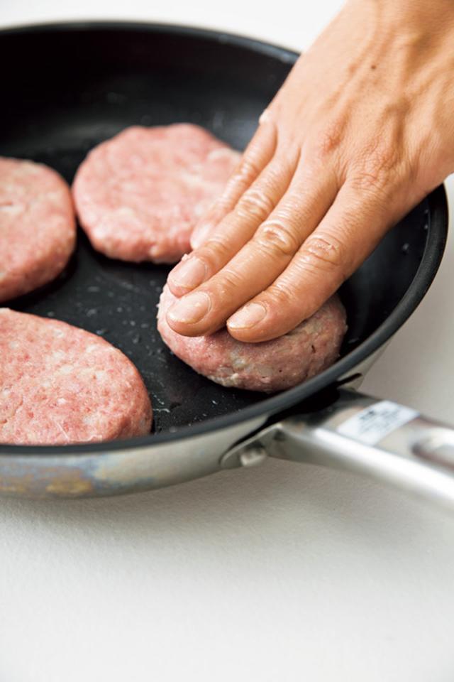 画像: フライパンに丸めた肉だねをのせ、その場で押さえて広げ、くぼみをつける