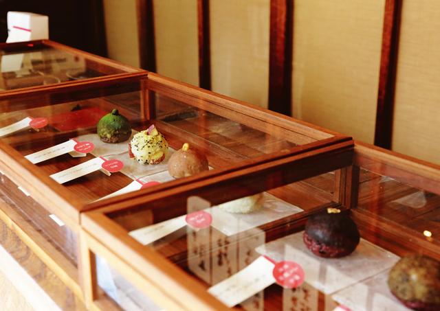 画像: 味わいのある木枠のケースには、色とりどりのおはぎのサンプルが並ぶ