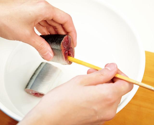 画像: 薄い塩水の中で、割り箸で内臓を押し出して取り除く
