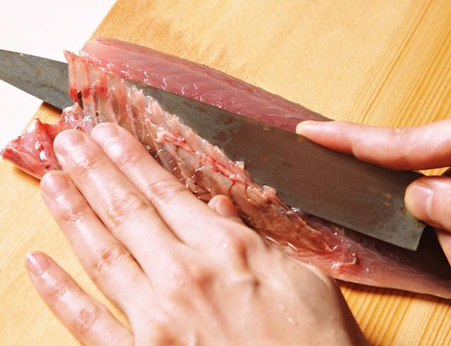 画像: 包丁をねかせて、腹骨をきれいにすき取る。端は刃を立てて落とす