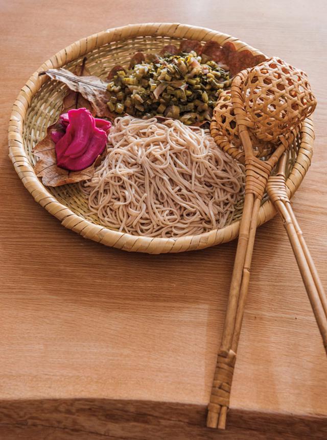 画像: 木曾から送られてくる伝統食・すんき漬けを使って、毎年すんきそば鍋を作ります。投汁籠(とうじかご)にそばを入れて投じ(温め)たら椀へ。酸味がおいしい一品。