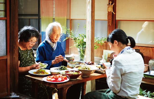 画像: 川口さん、洋子さん、摩紀さんとで縁側の食卓を囲むひと時。「洋子さんのお料理がおいしいから、いつもここでいただくのが楽しみ」と笑う摩紀さん