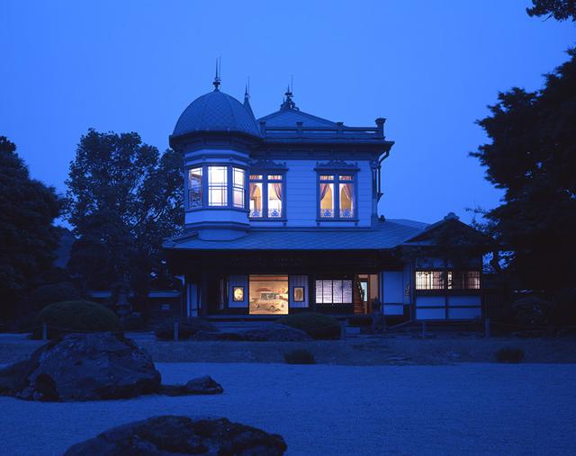 画像: 宵闇に溶け込む建物のシルエットに邸宅の灯りが幻想的に浮かび上がる