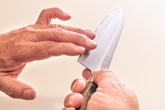 画像: バリを確認するときは、指3本ほどを使い、指先で刃の側面から刃先に向かいなでるようにする。指を切る恐れがあるので、刃先だけをなぞるような触れ方はしないこと
