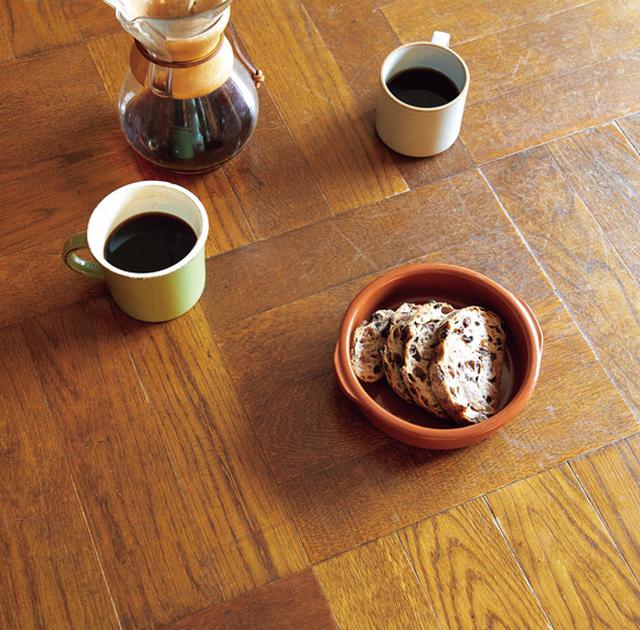 画像: テーブルの天板は寄木になっている。コーヒーを入れるのは正一郎さんの役目。おやつはタルイベーカリーのパン