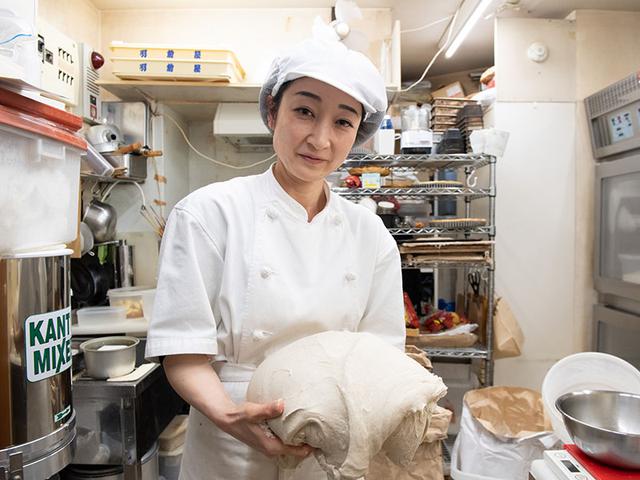 画像: オープン当初から石井さんの片腕として働くスタッフの弥生さん。日々変わる酵母の状態を見極めながら、毎日同じ味になるように焼き上げる