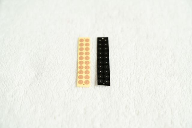 画像: 合金の「つぶ」(マグレイン)。手足やお腹などに貼る金メッキ(左)と、顔に貼っても目立たないチタン(右)