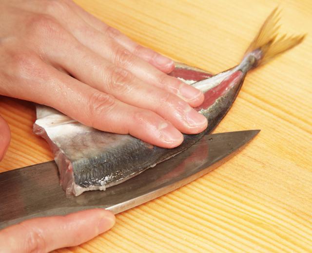 画像: 包丁をねかせて、刃先に骨が当たるのを確認しながら、中骨を切り離す
