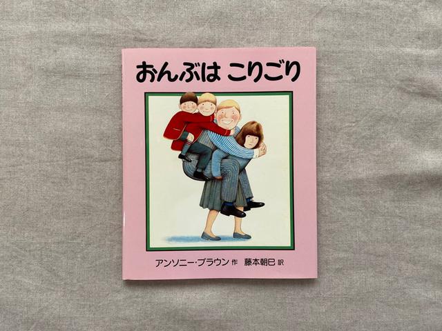 画像: 満面の笑顔でおんぶされているおとうさんと子どもたちにひきかえ、おかあさんの表情は……。