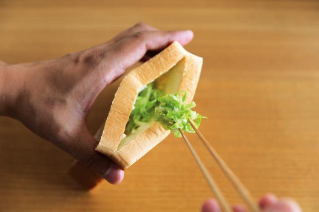 画像: 4枚切り食パンの脇から切込みを入れてポケット状に。そのポケットに、味付けしたせん切りキャベツを、詰めている。