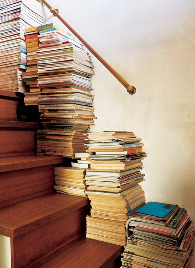 画像: 階段の幅を利用しない手はない。たくさんある蔵書は、家のあちこちに積まれている