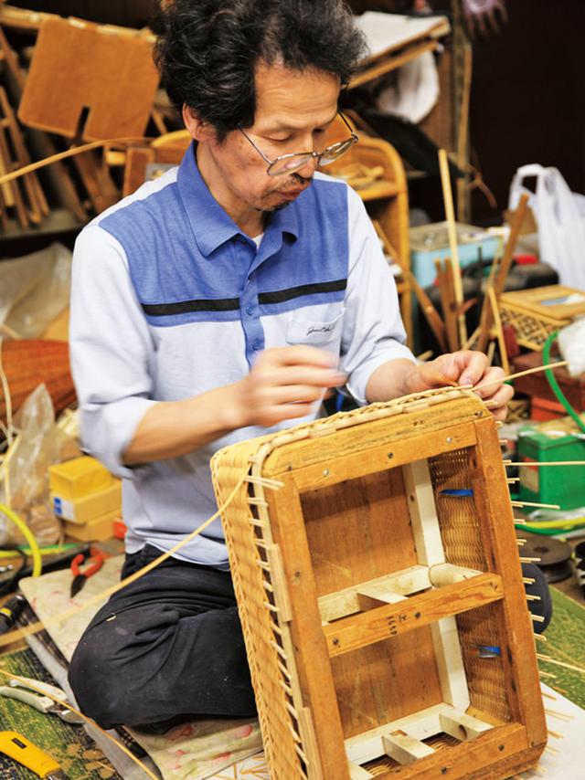 画像: 脱衣かごの上の部分を編む三男の利蔵さん。オーダーごとに3人の役割分担は変わる