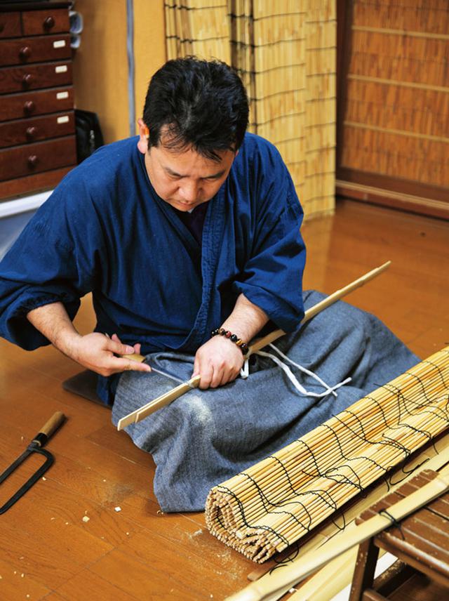 画像: 編み上がったすだれの上下に竹を付けて仕上げるのは、五代目を継ぐ予定の息子さんが担当