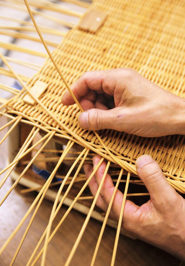 画像: 底の部分を編み終わったかごは、木型に打ちつけて仮留めする。横の部分を立ち上げながら編み進めると、見る見るうちに立体になっていく